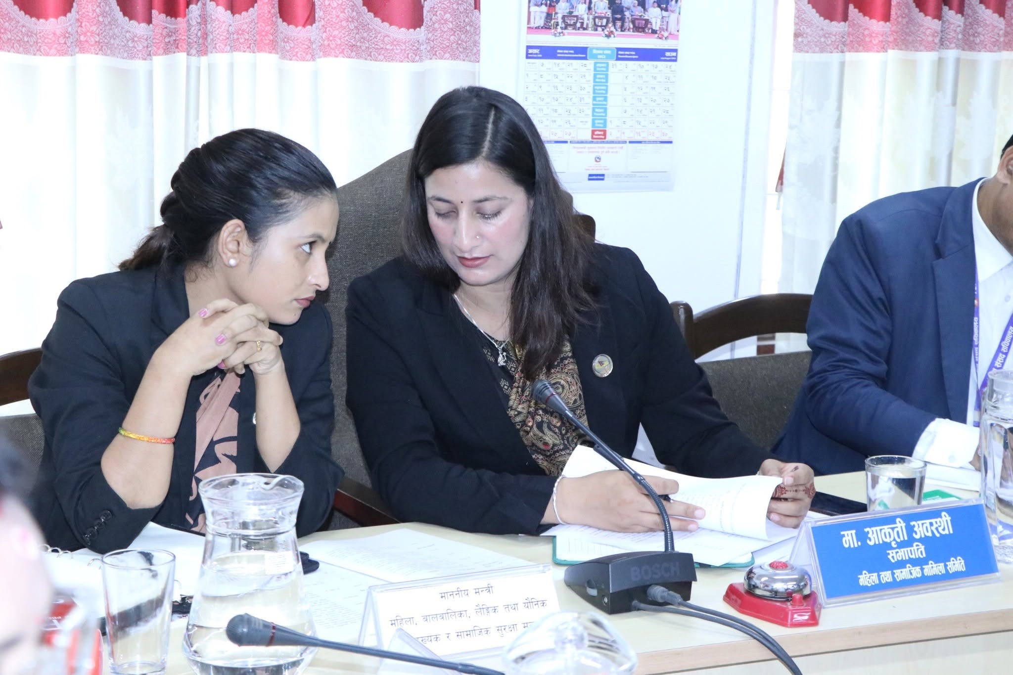 Aakriti Awasthi and a committee member reviewing meeting documents