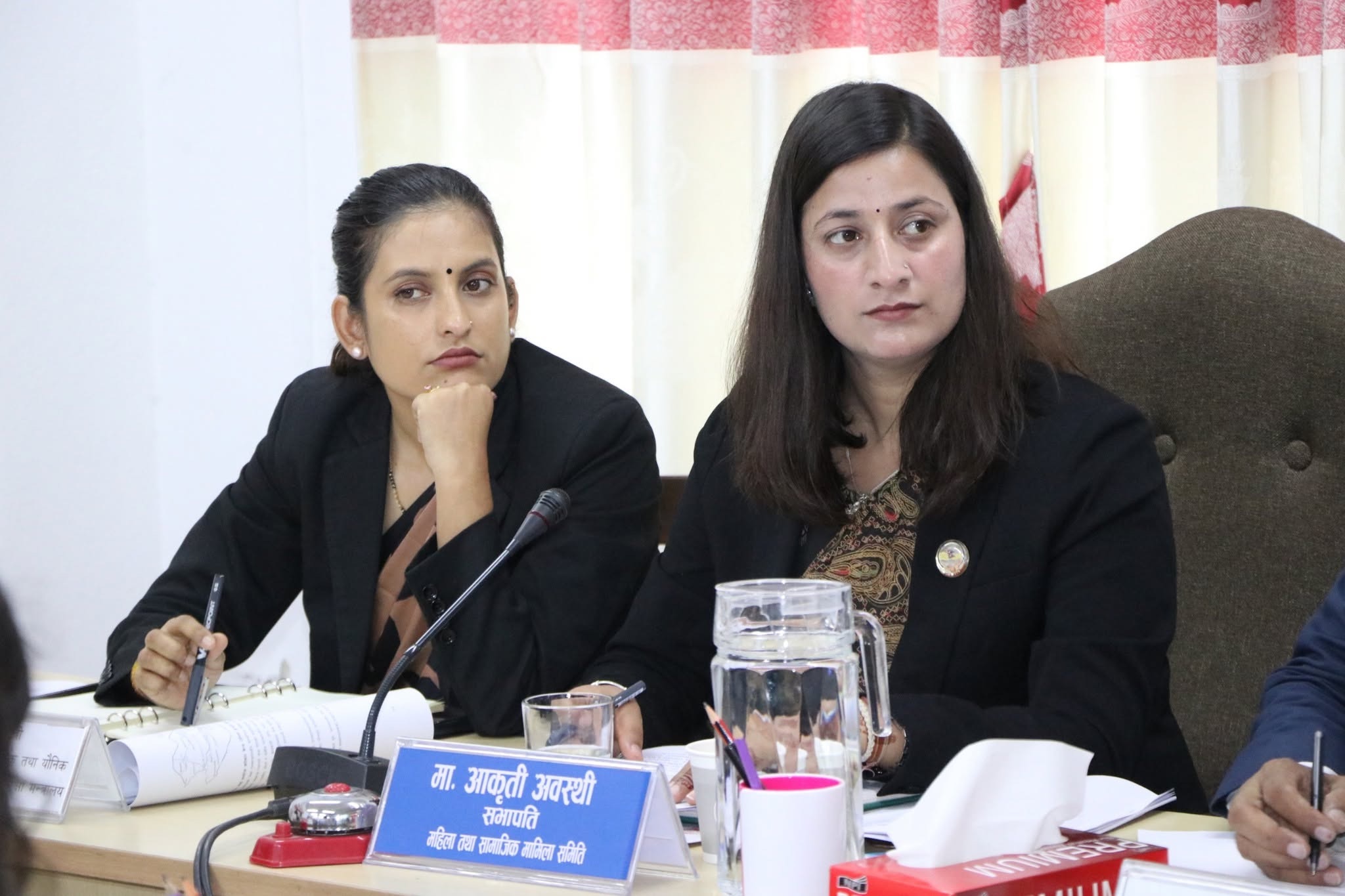 Aakriti Awasthi and a committee member listening during the meeting